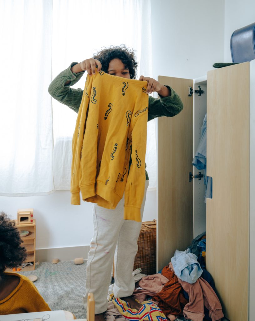 boy holding a yellow sweatshirt