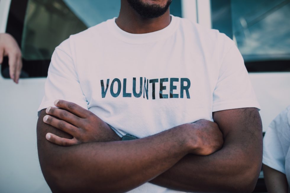 man wearing a volunteer shirt for fundraiser
